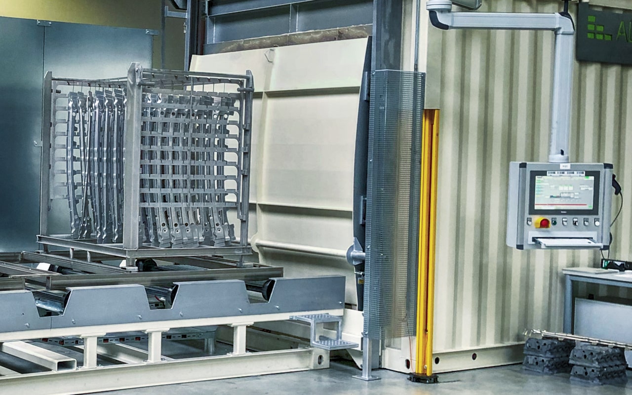 Bauteilgestell vor einer industriellen Wärmebehandlungsanlage für Aluminium